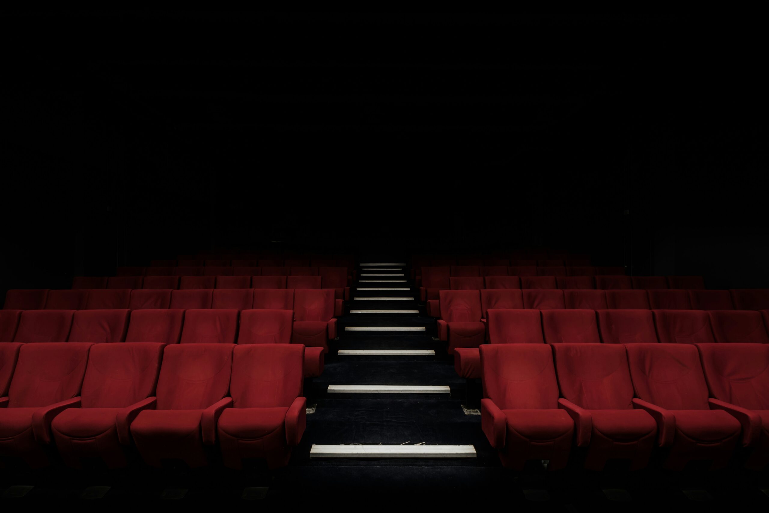 a row of red seats in a movie theater